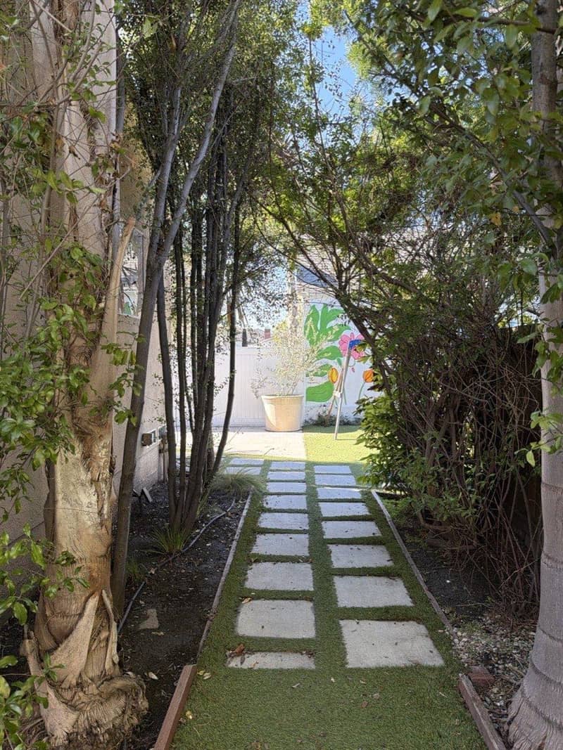 Stepping-stone garden walkway leading to a flower mural