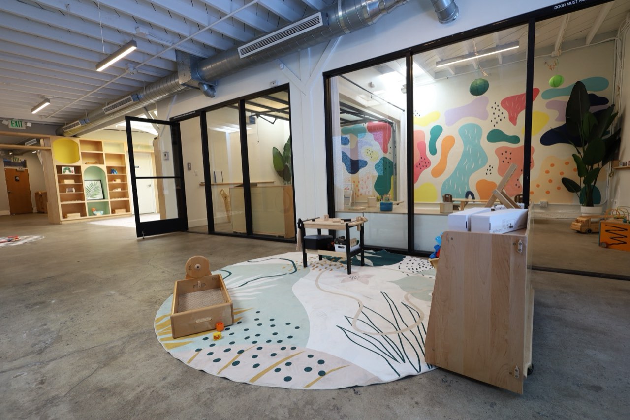 Play area with colorful mural and glass studios