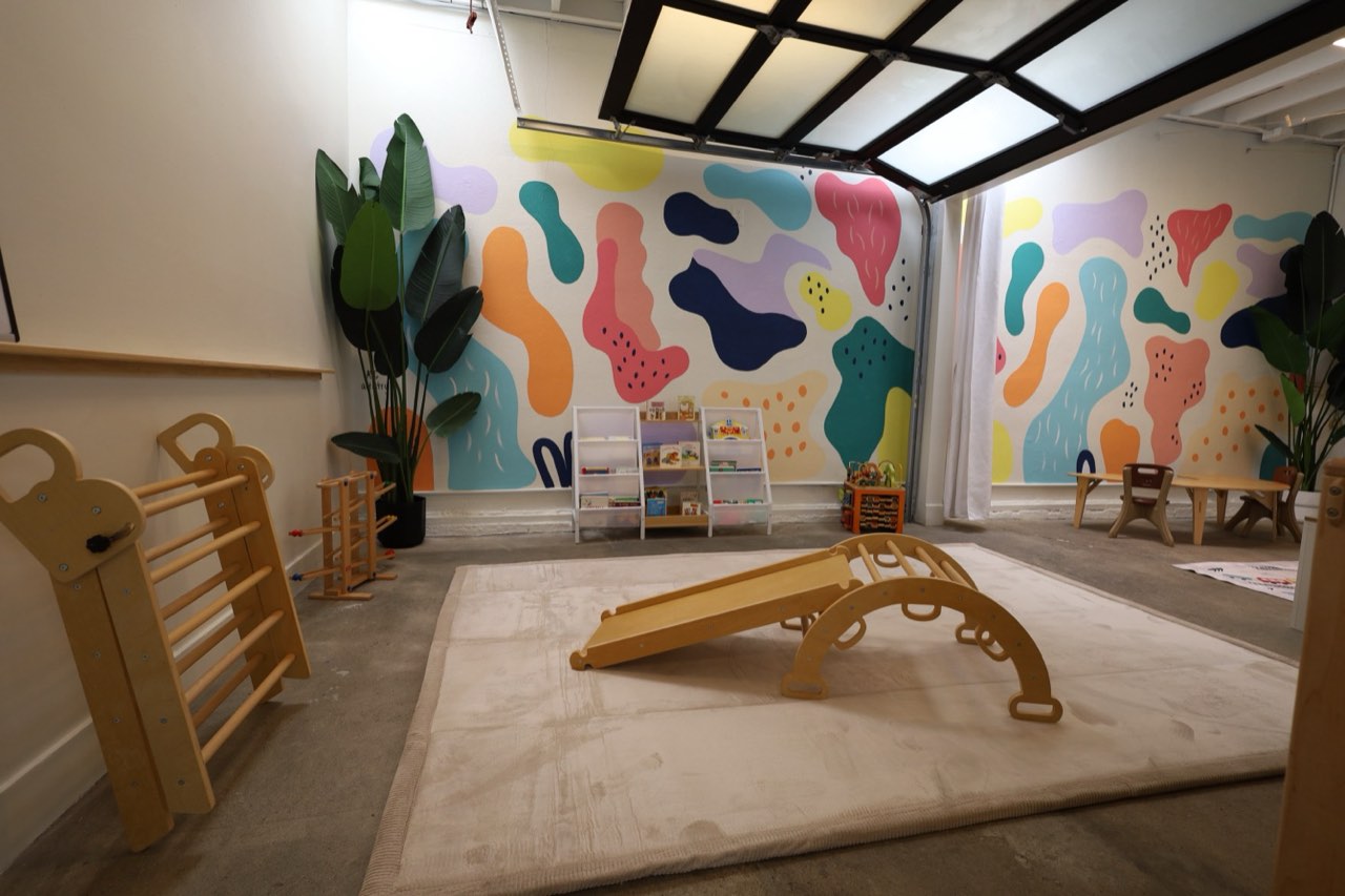 Bright Footsteps playroom with mural and climbing ramp